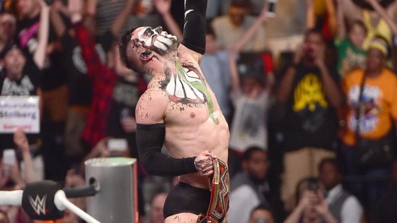 Finn Balor poses with the WWE Universal Championship after a victory over Seth Rollins at WWE SummerSlam 2016.