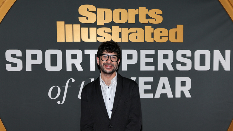 Tony Khan stands in front of one of several awards he and his company would take home by Sports Illustrated, including "Sports Person of the Year"