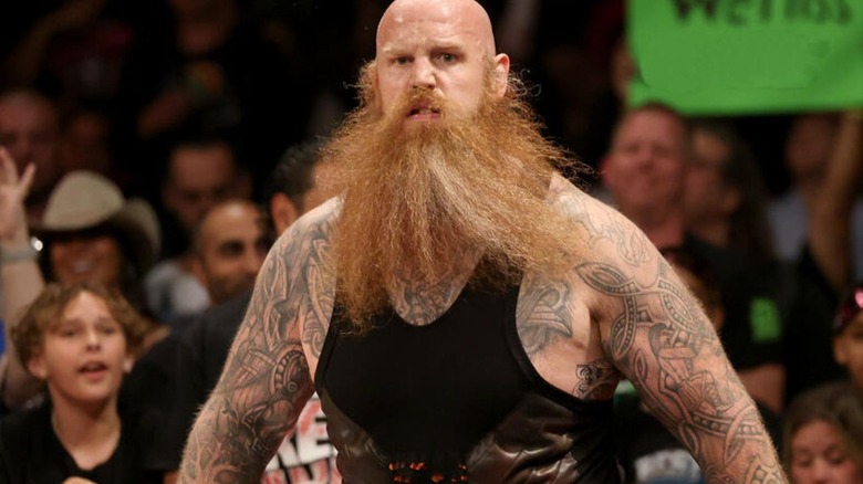 Erick Rowan moves toward an opponent on the outside of the ring during a match on WWE programming.