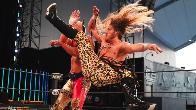 Joey Janela hitting a spin kick on Cody Rhodes