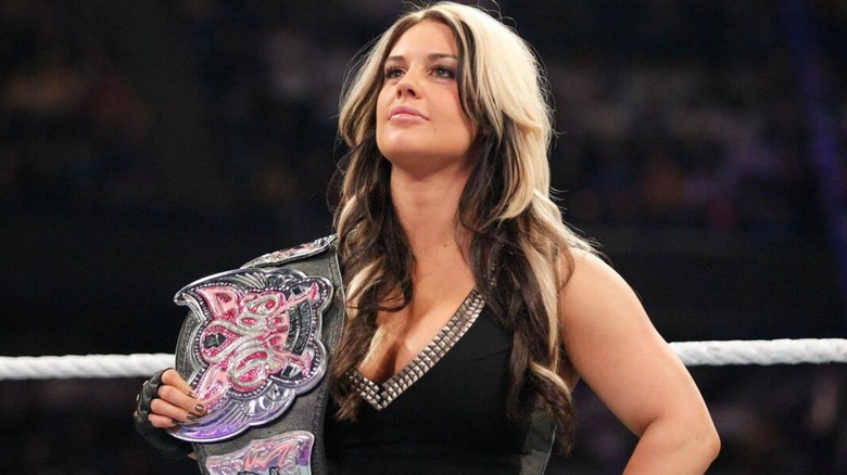 Kaitlyn in ring posing with the WWE Divas Championship ahead of a match.