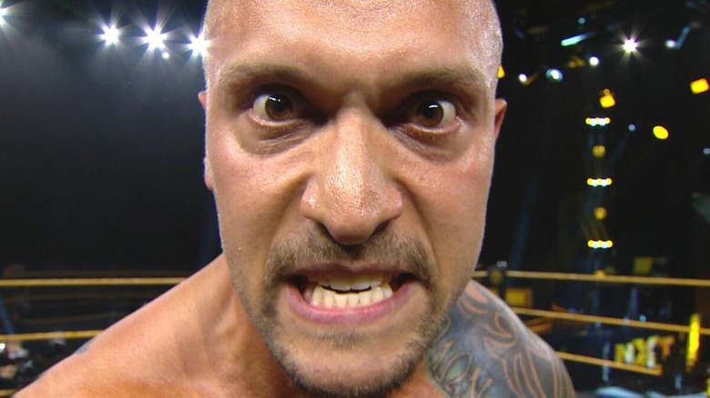 Karrion Kross mira fijamente a un agujero de la cámara en un show de NXT.
