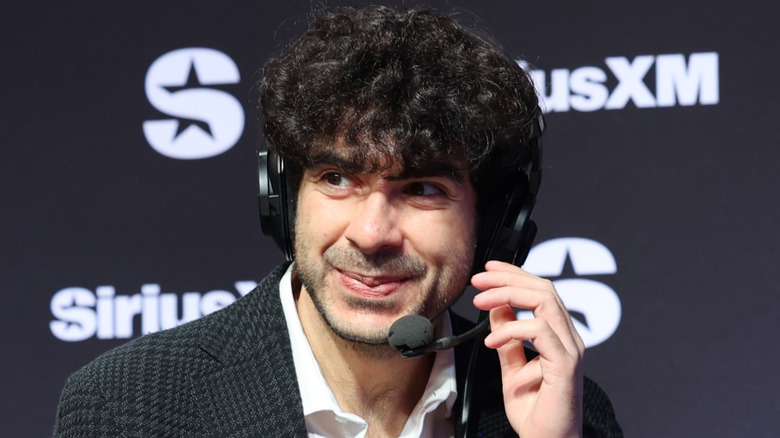 Tony Khan smiling while wearing a headset