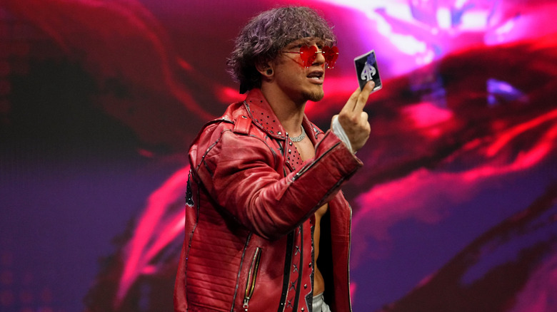Ace Austin poses with his ace card on the stage ahead of his first AEW match against Ricochet on 