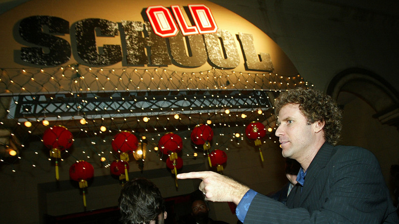 Actor Will Ferrell pointing in front of the logo for the movie Old School