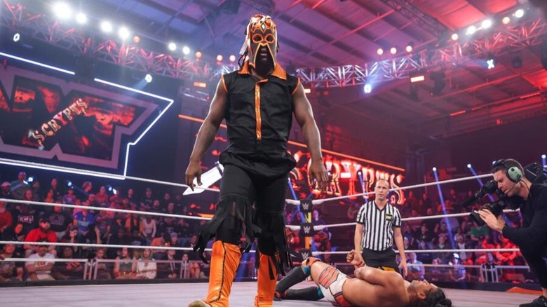 Former WWE star Scrypts, also known as Reggie in WWE, stands masked in the ring after a victory on 