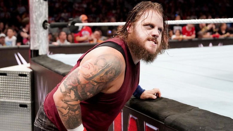 WWE star Joe Gacy, as a member of the Wyatt Sicks, stands ringside during a match on an episode of "WWE Raw."