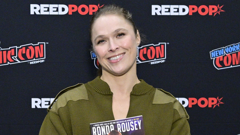 Ronda Rousey holds up her book