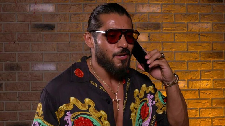 Santos Escobar talking on the phone during a backstage promo segment.