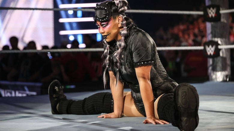 Wendy Choo, poses as her sleep paralysis demon gimmick in her pajamas in the middle of the ring, during an episode of WWE programming.