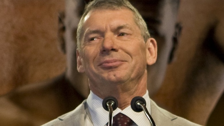 Vince McMahon looking away smiling