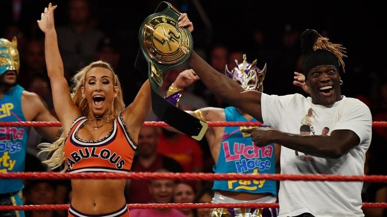 R-Truth raises Carmella's hand in victory after she defeated him for the WWE 24/7 Championship.