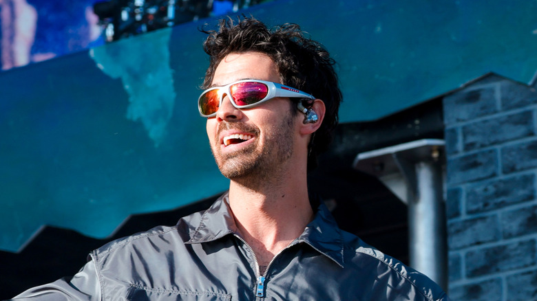 Joe Jonas performing while wearing shades