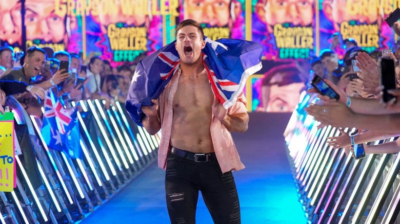 Grayson Waller heads down to the ring draped in an Australian flag during WWE's Elimination Chamber premium live event.