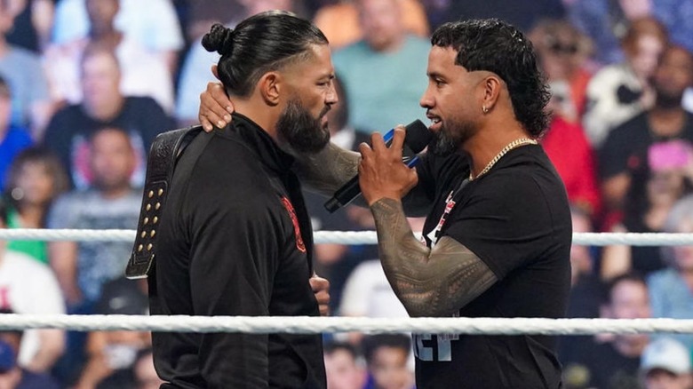 Roman Reigns and Jey Uso face off in the ring, with Jey speaking to his cousin in a slight embrace.