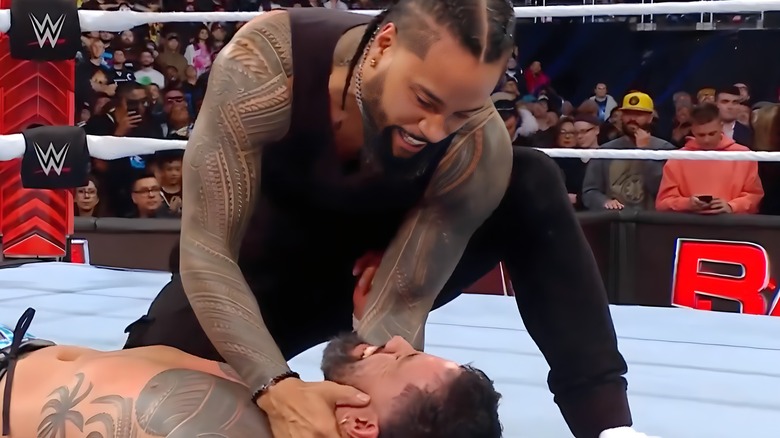 Jimmy Uso holding Jey Uso's head in his hands