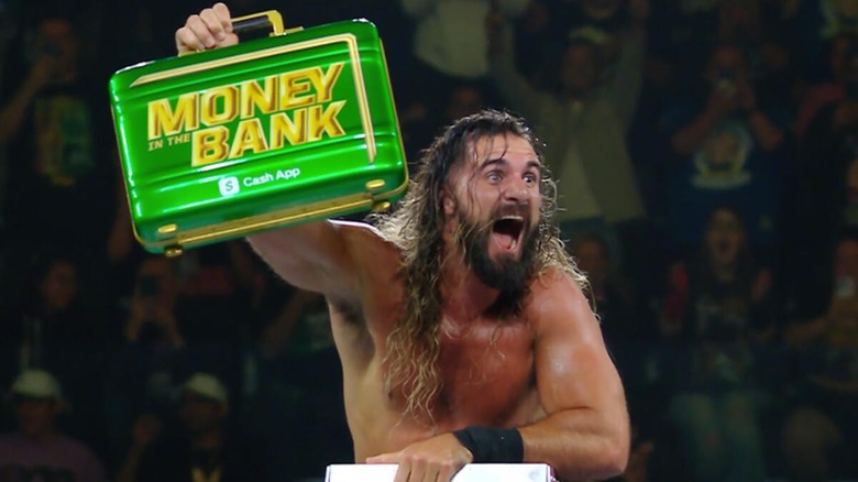 Seth Rollins holding the Money in the Bank briefcase above his head after winning it at Money in the Bank, 2025.