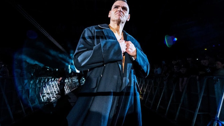 GUNTHER poses on the ramp as he looks to the crowd during his entrance at a WWE live event.