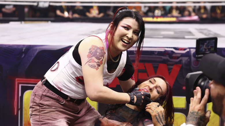 Hikaru Shida holds up Kris Statlander's face and smiles during their lights out street fight on an episode of 