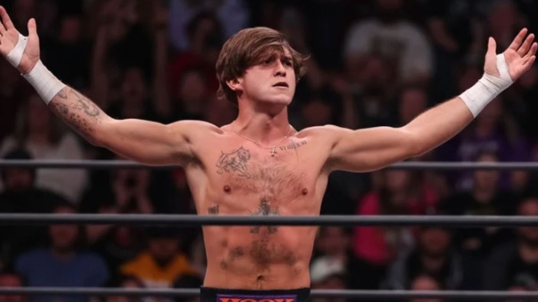 AEW's Hook stands in the middle of the ring and poses before a match.