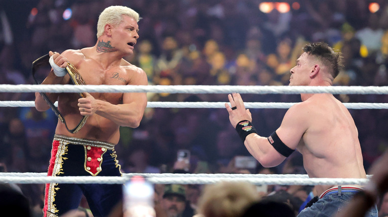 Cody Rhodes holding the Undisputed WWE Championship as John Cena begs him not to hit him with it