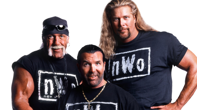 Hulk Hogan, Scott Hall and Kevin Nask pose for a photo wearing black and white NWO shirts.