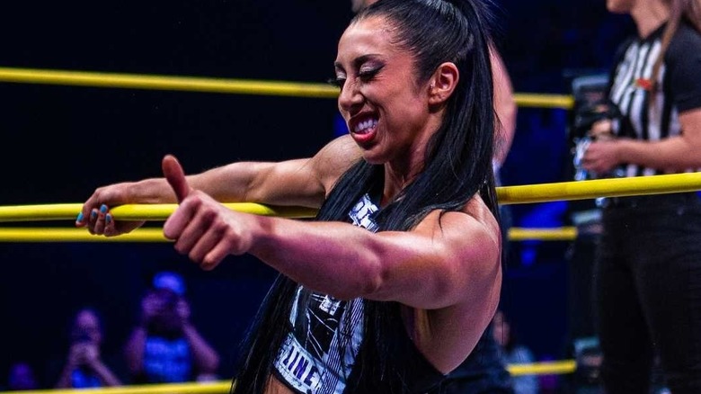 Indi Hartwell winks and smiles as she holds a thumbs up.