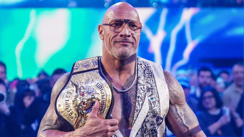 The Rock carrying his People's Championship to the ring