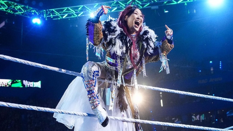 IYO SKY hits her signature emote on the ropes before a match at a WWE premium live event.