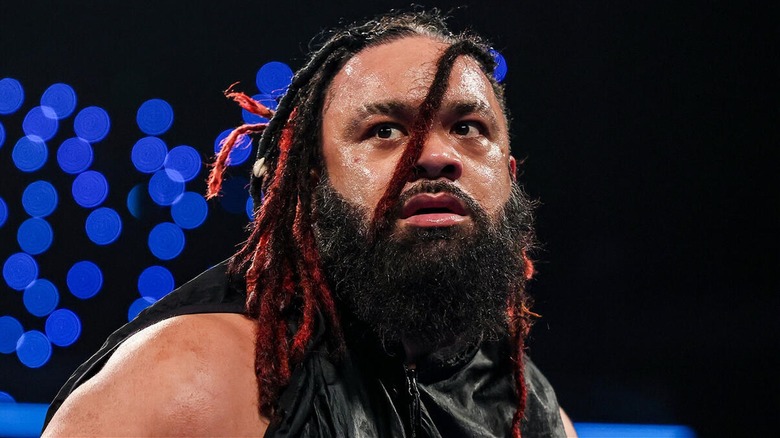 Jacob Fatu looks on during an in-ring segment on a WWE show.
