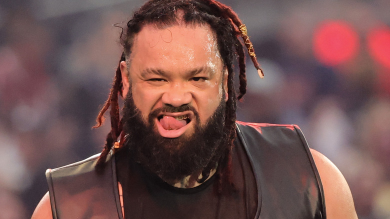 Jacob Fatu licks his gold-gilded teeth menacingly during his entrance.