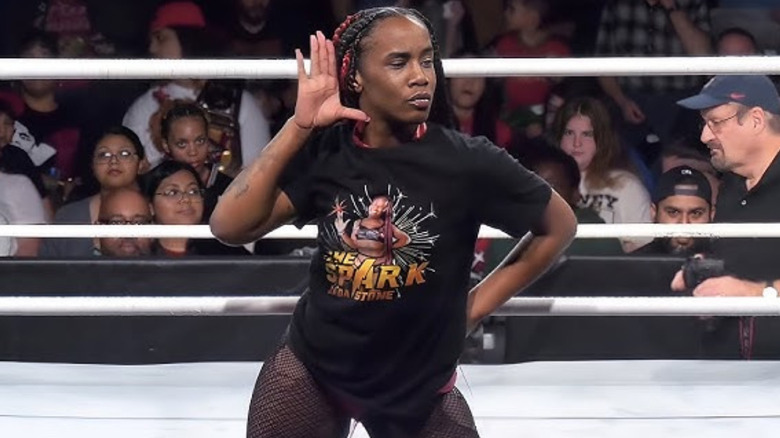 Jada Stone putting a hand up to her ear
