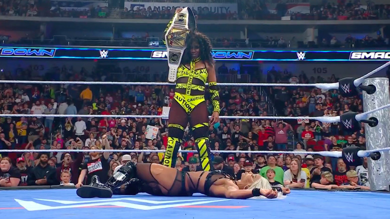 Naomi holding the WWE Women's title up