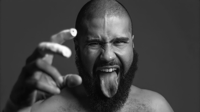 A monochrome image of Jaka Jonathan Echevarria posing with his tongue out and hand raised