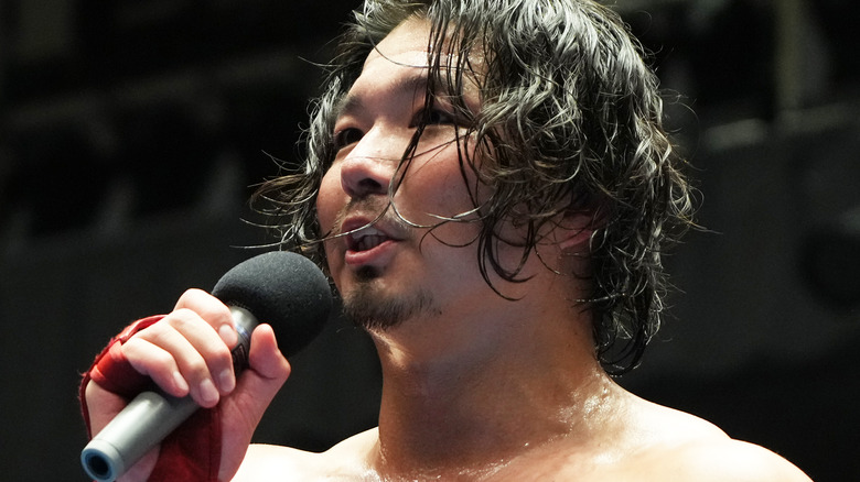 Jake Lee talking into a microphone at an AJPW show