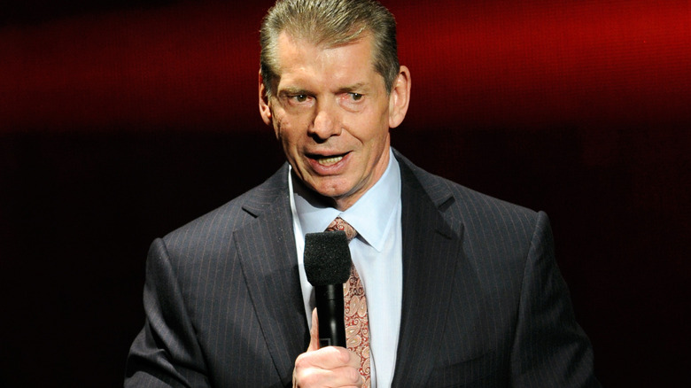 Vince McMahon speaks on the microphone.
