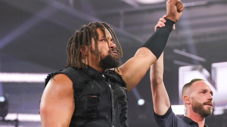 A referee raises the hand of Jasper Troy after a victory on 