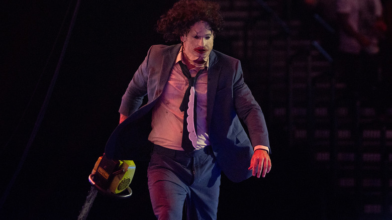 Leatherface runs around the arena with a chainsaw
