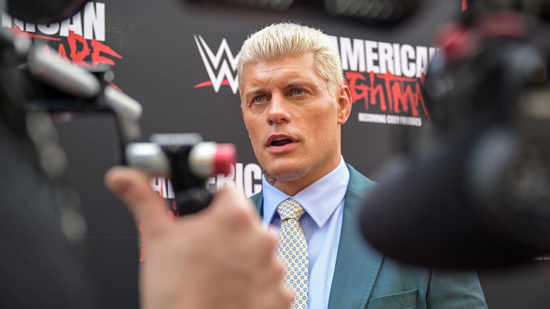 Cody Rhodes obscured by camera people