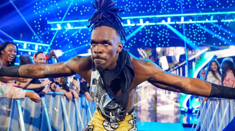 Je'Von Evans high fives fans as he heads down the ramp to the ring, a serious look on his face, for a match on an episode of WWE programming.