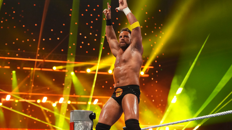 LA Knight holds his hands up as he makes his iconic entrance.
