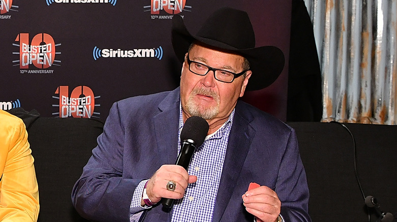 Jim Ross talks while appearing to make a fist with his left hand