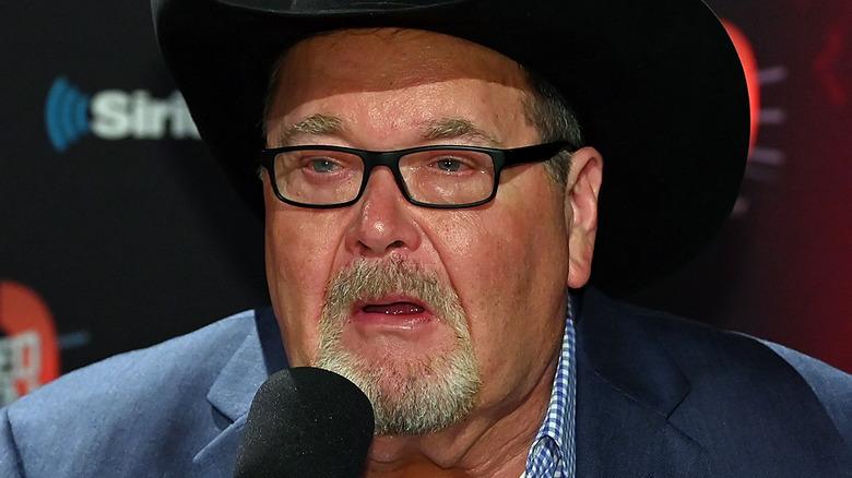 Jim Ross holds microphone