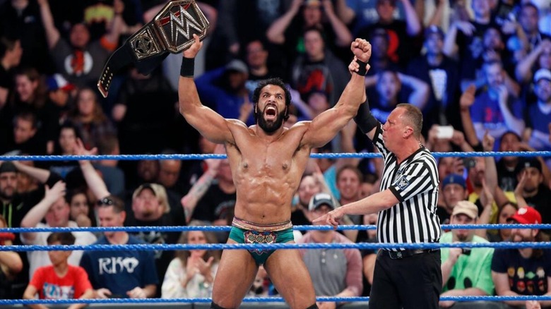A referee holds up the arm of Jinder Mahal, who holds his newly-won WWE Championship, after a victory on an episode of WWE programming.