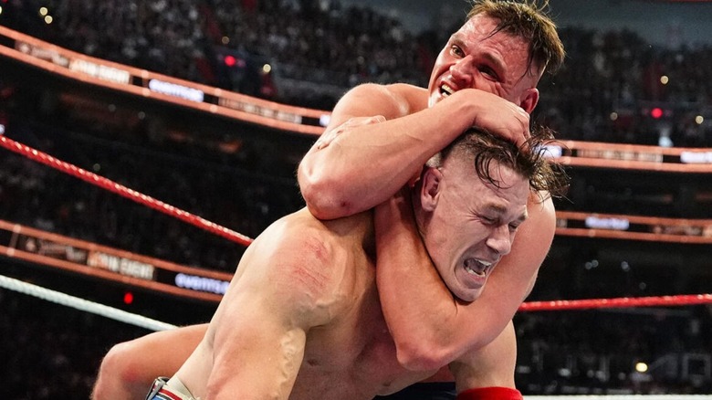 John Cena attempts to fight out of GUNTHER's sleeper hold in the ring during their match at WWE Saturday Night's Main Event on December 13, 2025.