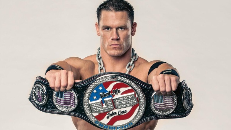 John Cena posing with his custom WWE United States Championship for a photoshoot.