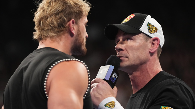 John Cena confronts Logan Paul on the microphone.