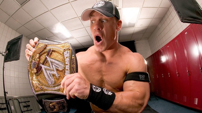 John Cena stares jokingly at his iconic WWE World Heavyweight Spinner Championship.