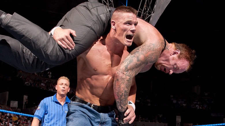 John Cena holding The Undertaker up on his shoulders for an Attitude Adjustment at WWE Vengeance 2003.
