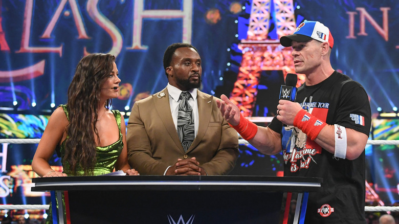 Jackie Redmond, Big E, and John Cena speak at the WWE Post Show desk during WWE Clash in Paris at Paris Le Defense Arena on August 31, 2025 in Paris, France.